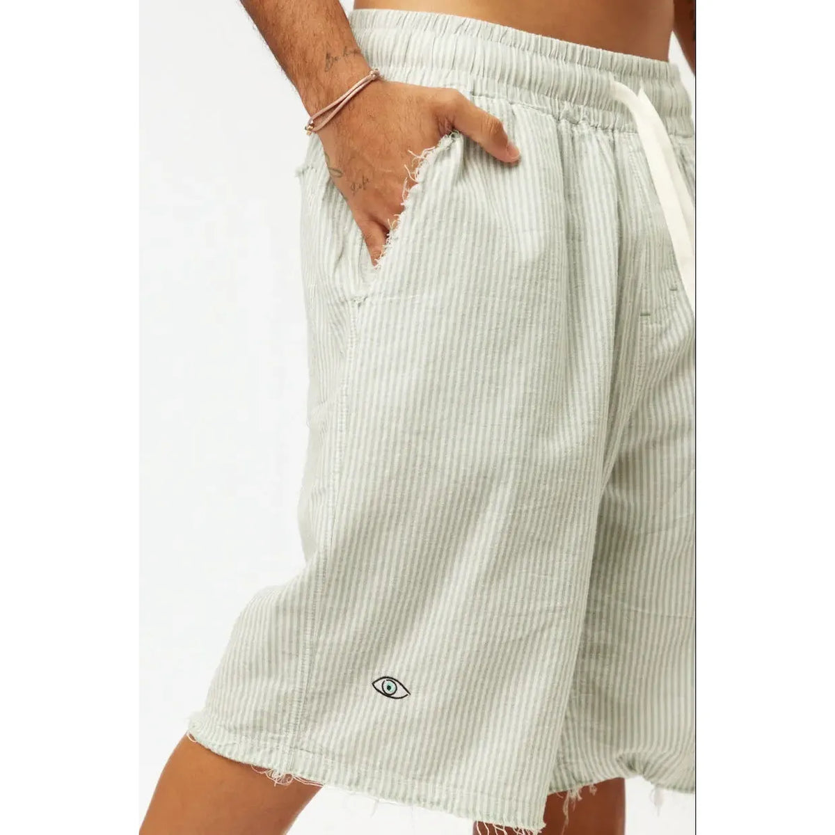 Striped Bermuda Shorts - Green with a hand in the pocket and an eye logo