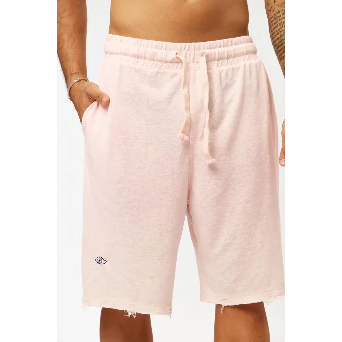 Base Shorts in baby pink with an eye logo and distressed hem