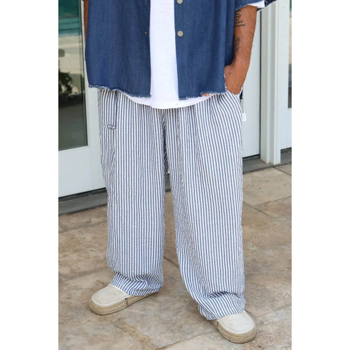 Pure Oversized Linen Pants in blue and white stripes, worn with a white t-shirt and blue denim shirt
