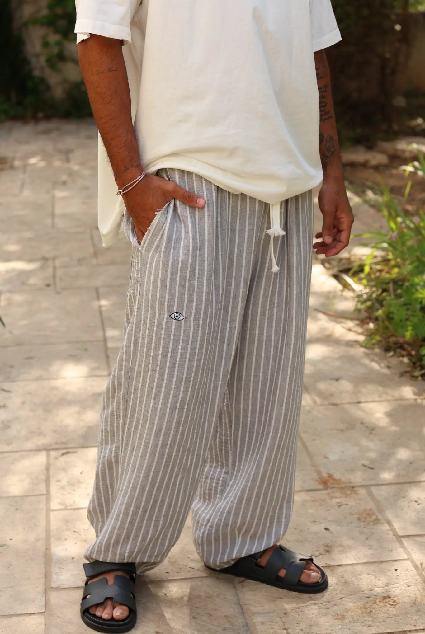 Pure Oversized Linen Pants in Grey & White Stripes, worn by a person standing on a paved surface