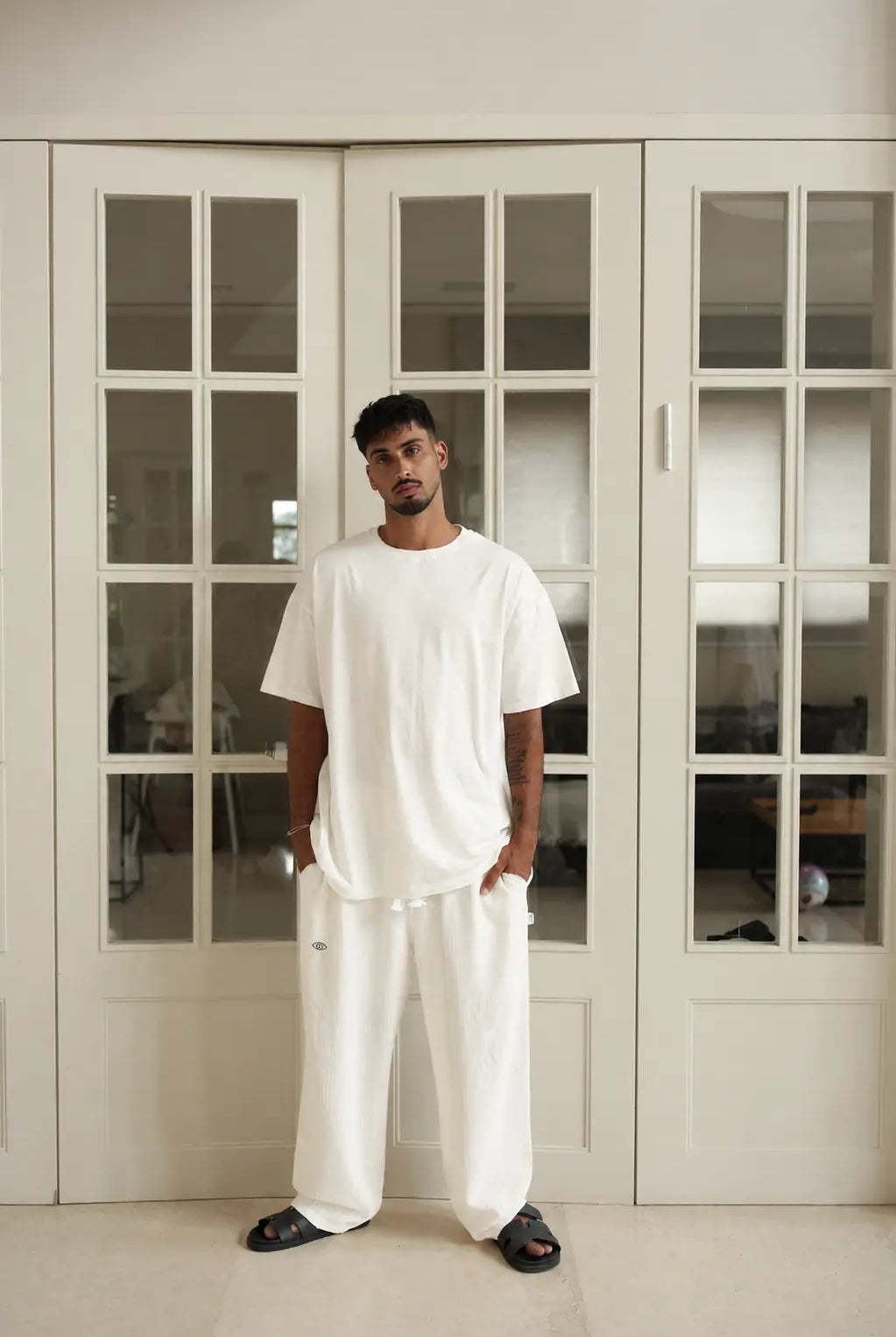 Man wearing cream white Pure Oversized Pants and a white t-shirt