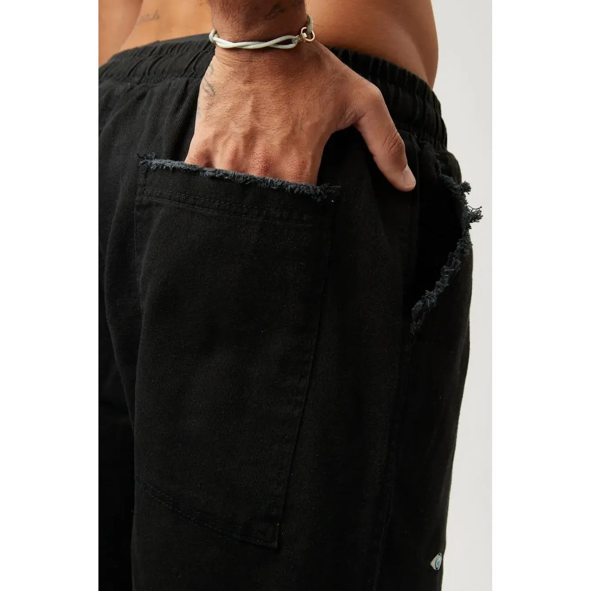 Close up of a person's hand in the pocket of DC Elastic Waist Pants with Elastic Hem in black