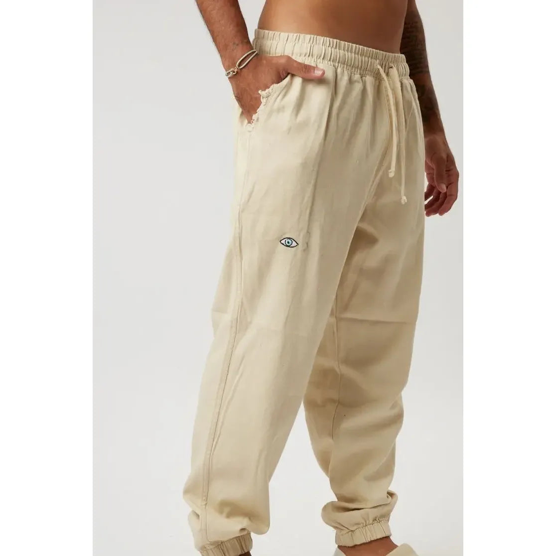 Stone DC Elastic Waist Pants with Elastic Hem, featuring a small eye logo on the thigh and a drawstring waist