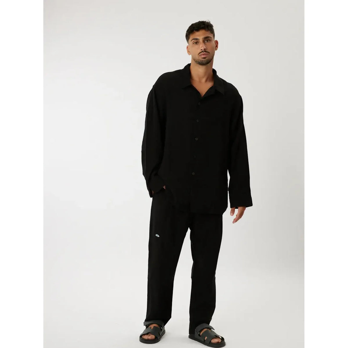 Man wearing a black long-sleeved shirt and black trousers from the LUX BLACK - SET