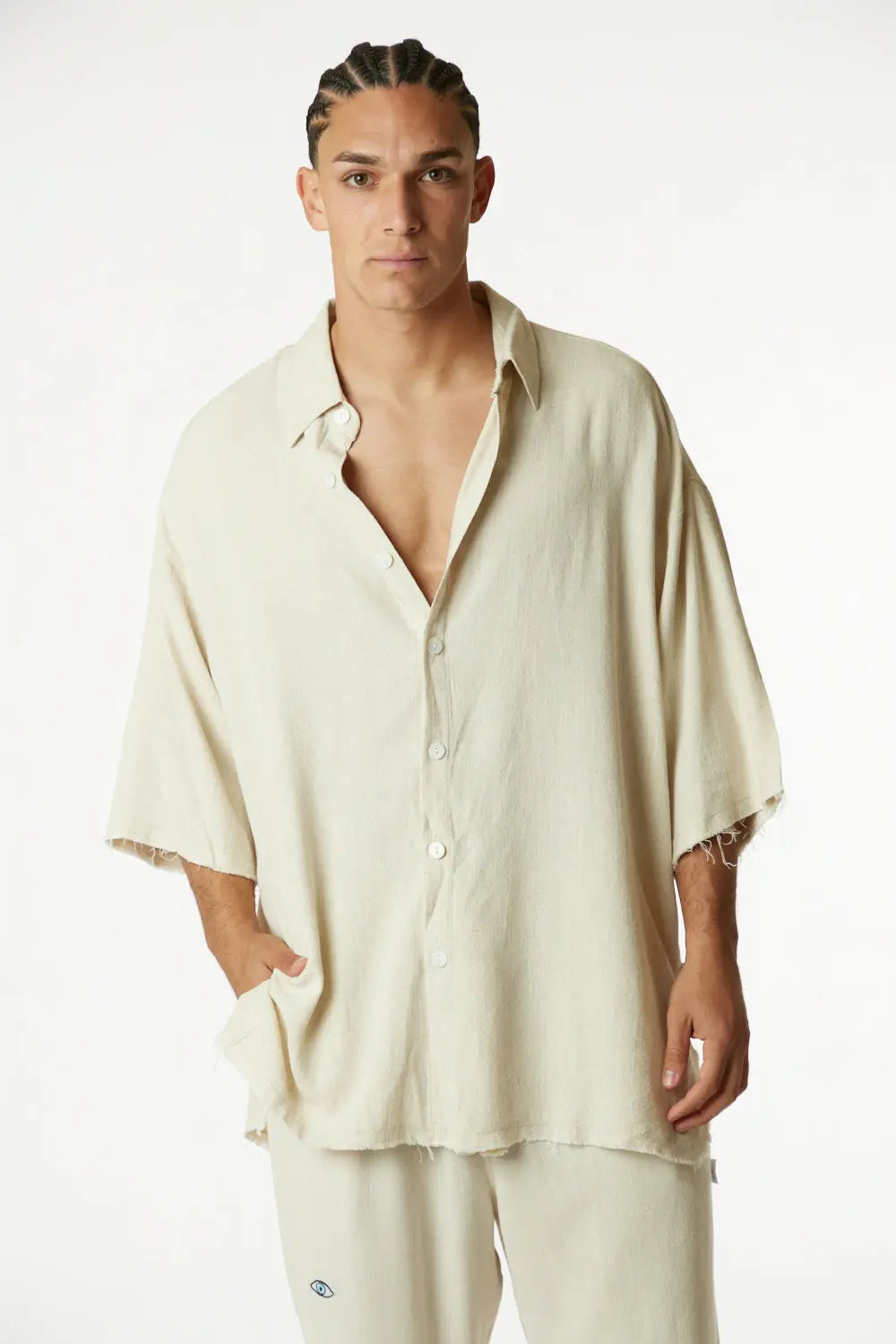 Man wearing a beige shirt and pants on a white background