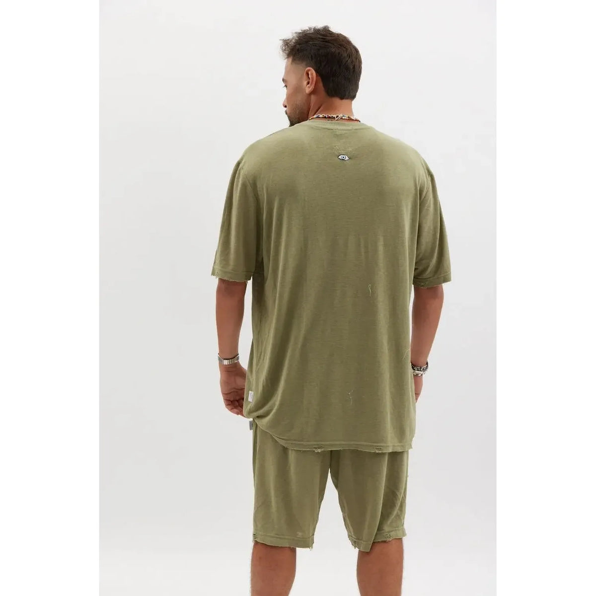 Man from behind wearing an olive TFU Soft Essential Tee and matching shorts