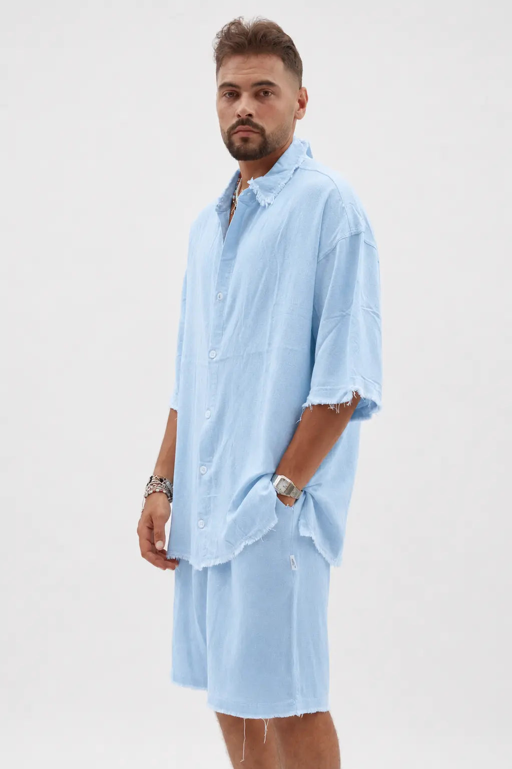 Man wearing a light blue soft linen bermuda shorts and matching shirt