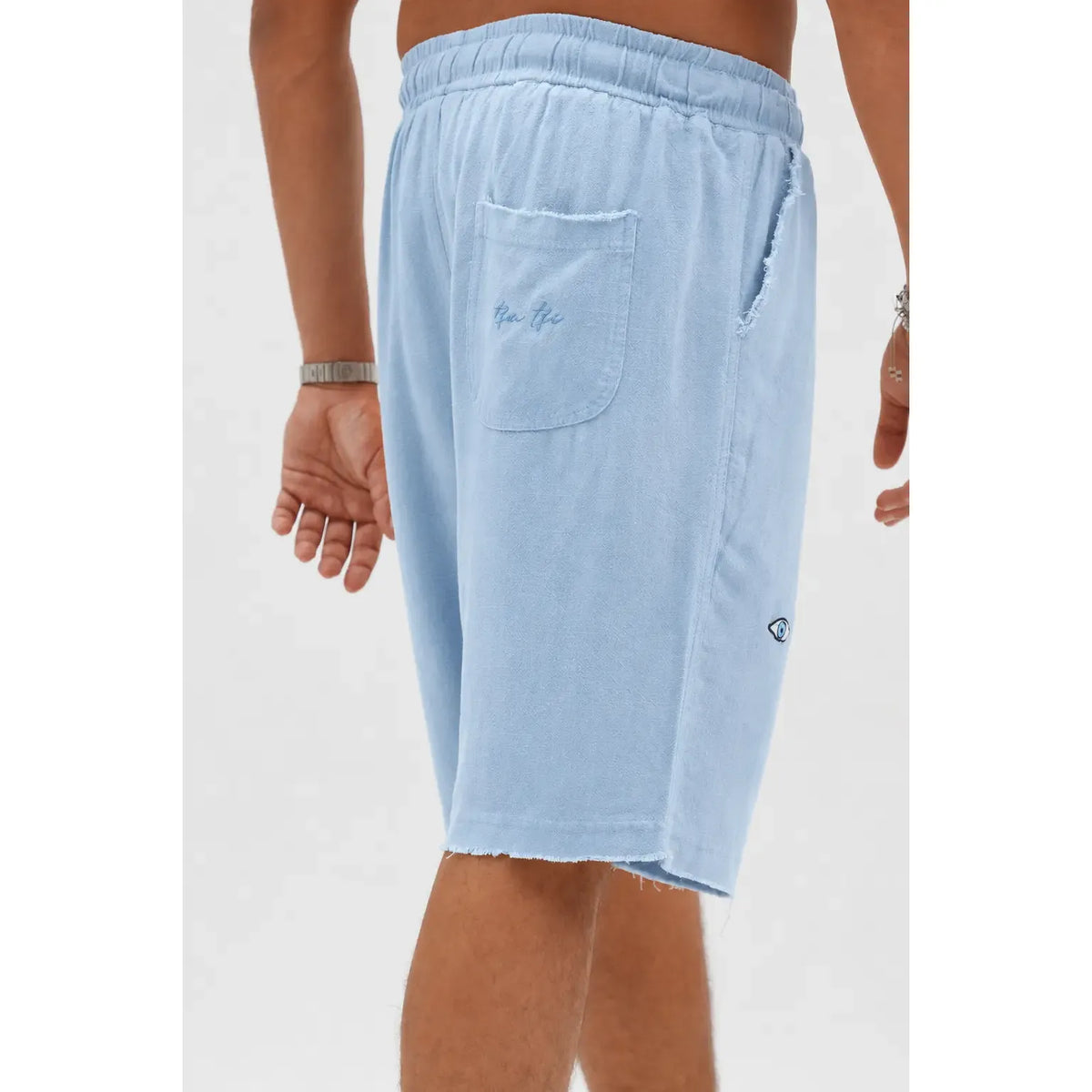 Soft Linen Bermuda Shorts in Sky Blue, with a back pocket and a small eye logo on the side