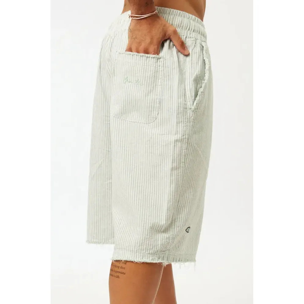 Striped Bermuda Shorts in green with a hand in the back pocket