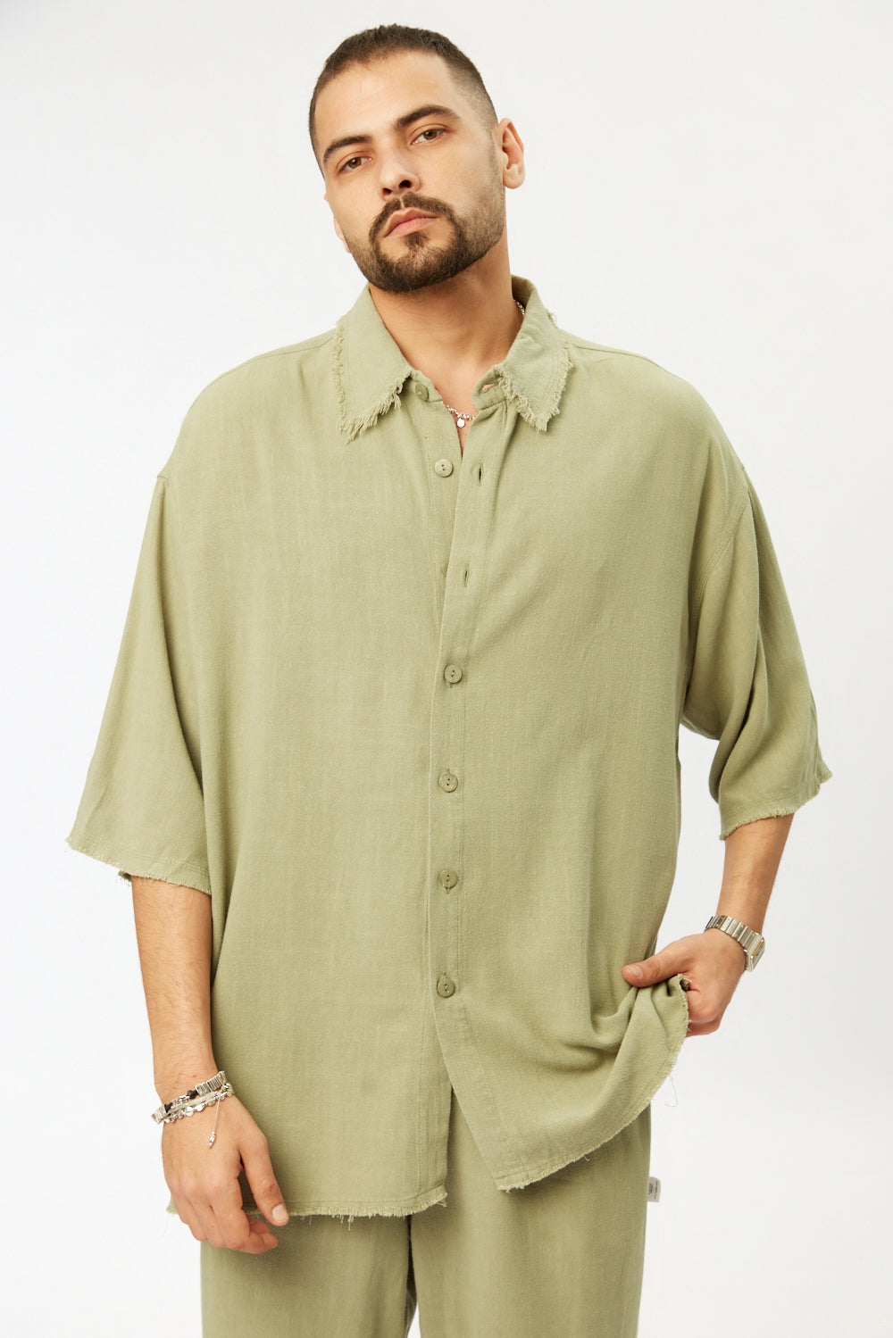 Man wearing a light green shirt and pants on a white background
