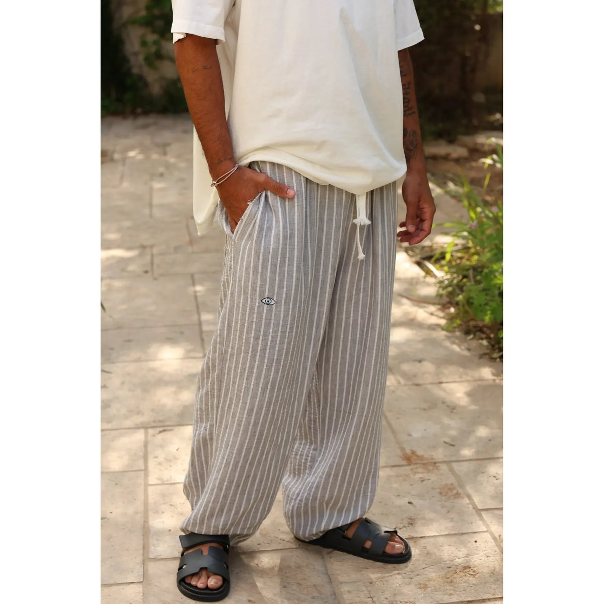 Pure Oversized Linen Pants in Grey & White Stripes, worn by a person standing on a paved surface