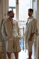 Two men wearing RIPS LONG SLEEVE -STONE shirts and matching shorts, standing in a doorway