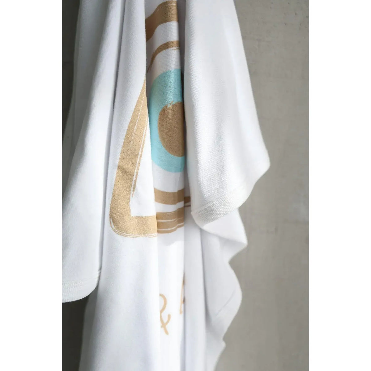 White garment with abstract patterns on a gray background