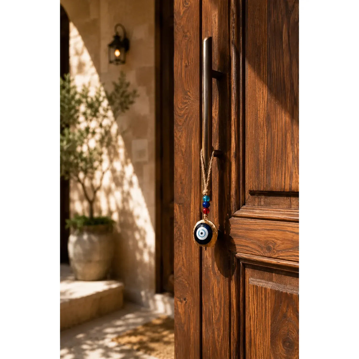 Single Hanging Bell Mobile with an evil eye charm and colorful beads, hanging on a wooden door handle