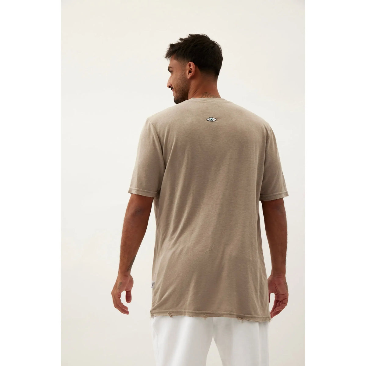 Back of Nicki Soft Open Top in light olive green with small eye graphic on upper back