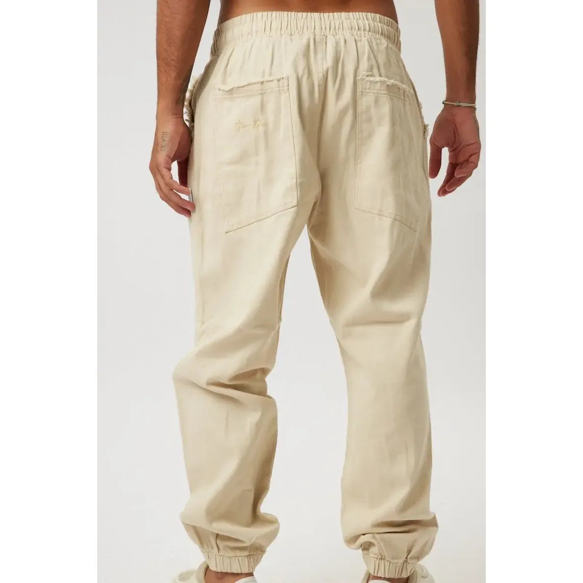 Back view of stone DC Elastic Waist Pants with Elastic Hem, showing the elastic waistband, back pockets, and elastic cuffs at the ankles