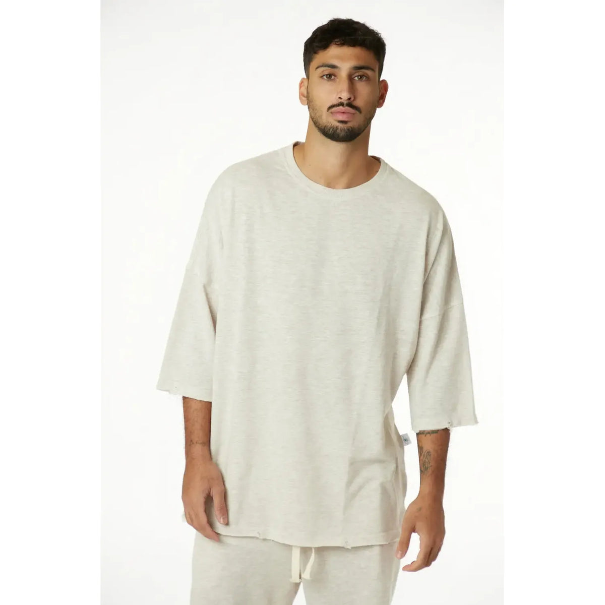 Man wearing a beige oversized shirt and pants on a white background