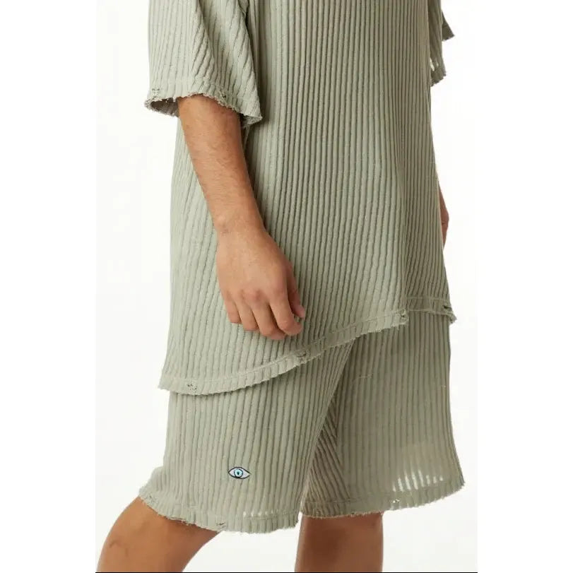 Khaki striped knit pants with an eye graphic on the left leg