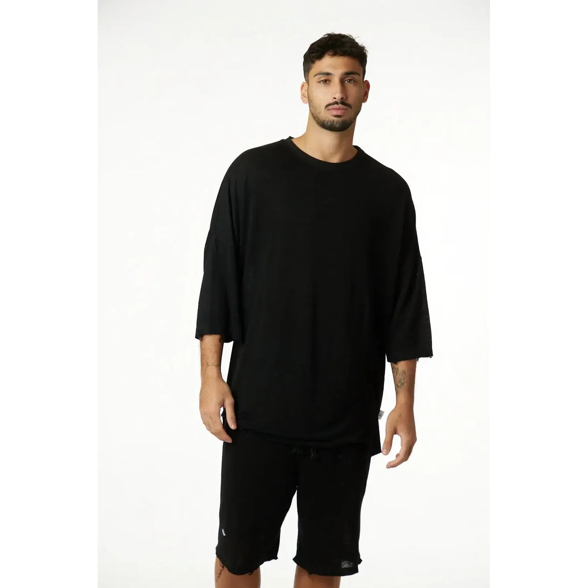 Man wearing a black 3/4 Sleeve Nicki Soft top and black shorts