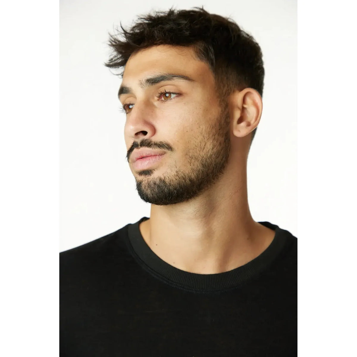 Man wearing a black 3/4 Sleeve Nicki Soft top, looking to the left