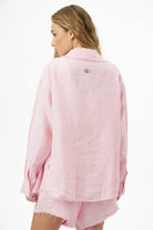 Back of a woman wearing a Pure Linen Women's Button-Up Shirt in pink and white stripes with an eye graphic on the back