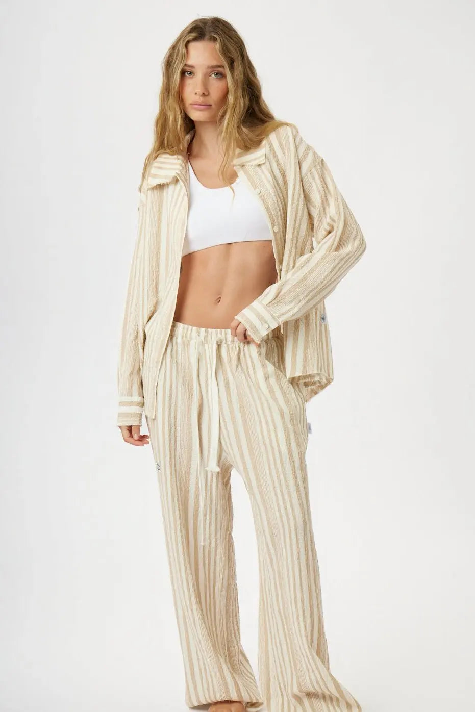 Soft Linen Women's Button-Up Shirt in beige and white stripes, worn open over a white bralette with matching striped pants