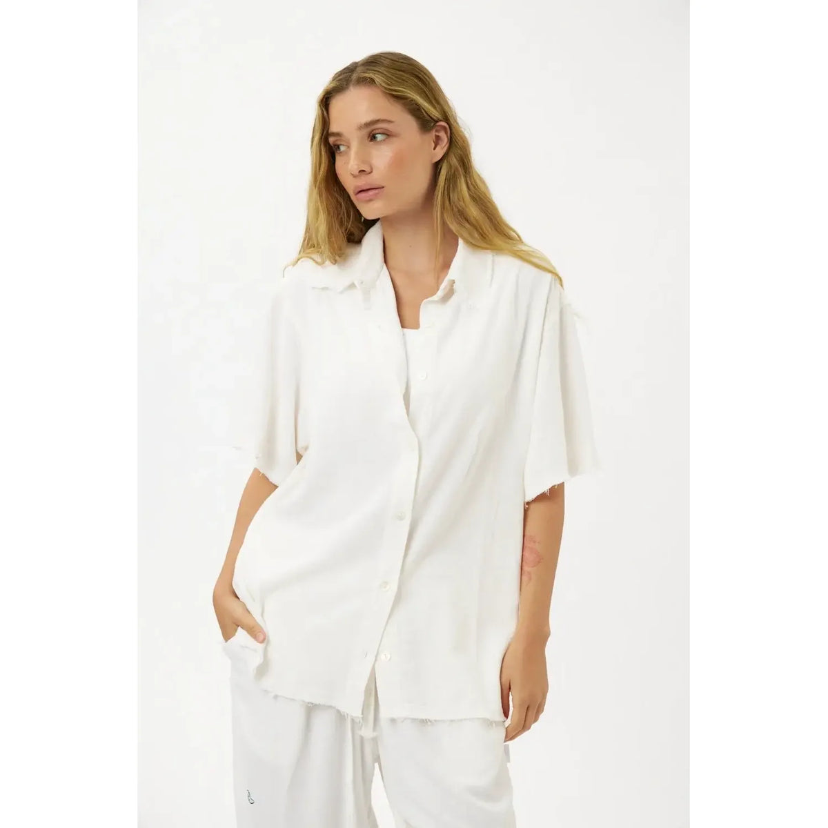 Woman wearing a white Soft Linen Short Sleeve Button-Up Shirt and matching white pants