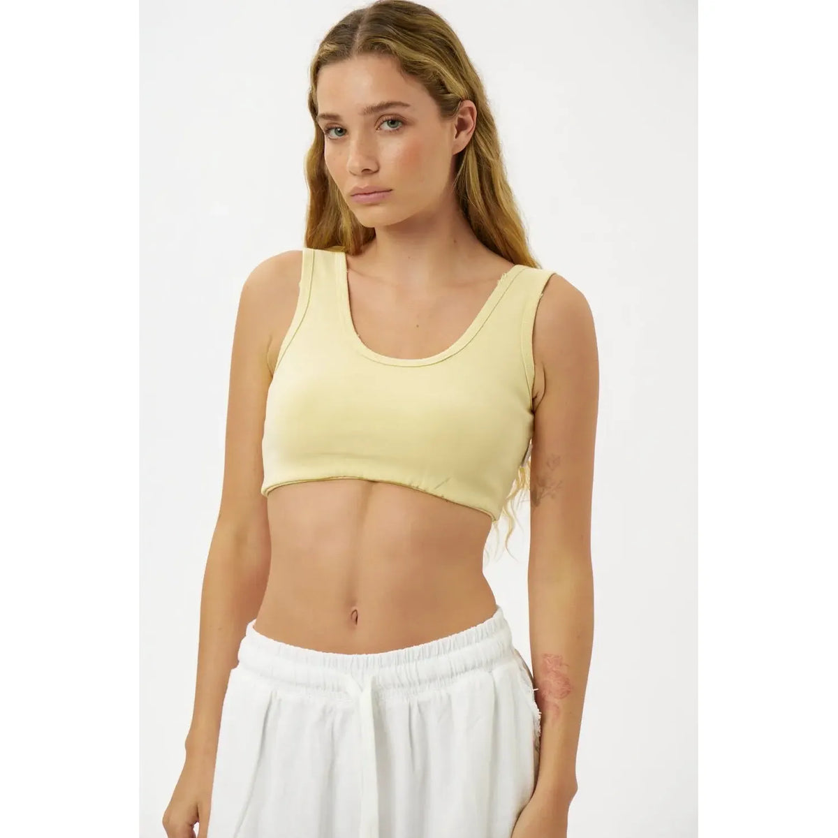 Essential Crop Top in yellow on a model with long blonde hair and white sweatpants