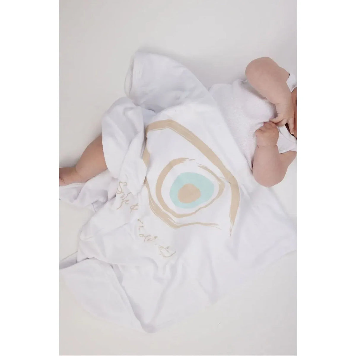 Baby covered by a white Cotton Single Elliptical Eye Blanket with a large eye graphic